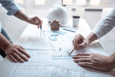 Mimarlar takımı veya mühendislik danışmanlık ve analiz nesneler üzerinde çalışma araçlar ve inşaat çizimleri teftiş, planlama ve model ev üzerine yeni mimari proje planlama.