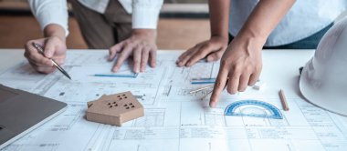 Mimarlar takımı veya mühendislik danışmanlık ve analiz nesneler üzerinde çalışma araçlar ve inşaat çizimleri teftiş, planlama ve model ev üzerine yeni mimari proje planlama.
