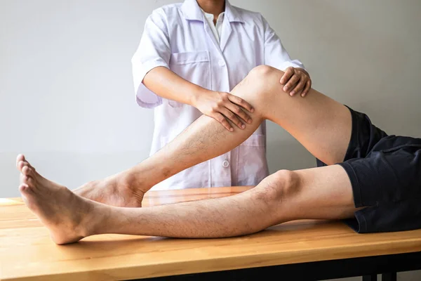 Doctor Physiotherapist Working Examining Treating Injured Leg Athlete Male Patient — Stock Photo, Image