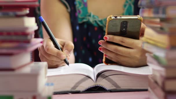 Вибірковий Фокус Жіночих Людських Руках Мобільним Телефоном Ручкою Написання Книзі — стокове відео