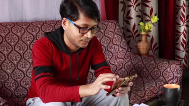 Ένας Ινδός Μεσήλικας Σερφάροντας Έξυπνο Τηλέφωνο Στο Σπίτι Κάθεται Στον — Αρχείο Βίντεο