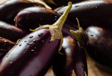 Ahşap bir yüzeyde, sığ bir alan derinliğinde patlıcan sebzeleri grubunu kapat.