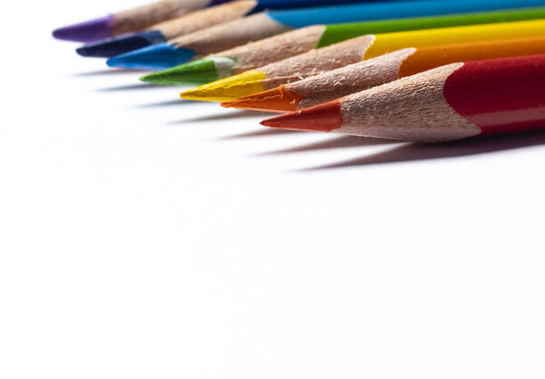 Close up view of rainbow color wooden pencils with shallow depth of field on white background