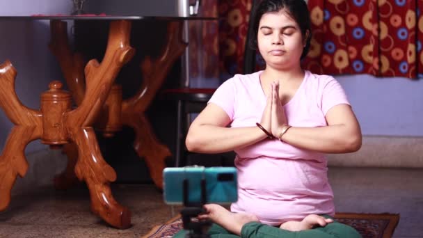 中高年のインドの家の妻は フィットネスヨガや瞑想のオンラインクラスを実行するスマートフォン フィットネスの概念の前に — ストック動画