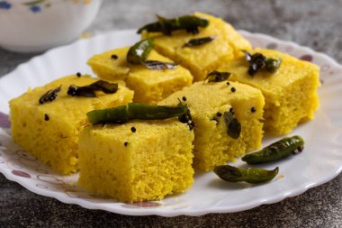 Sarı dhokla 'ya odaklan. Tabakta servis edilen Hint yemeği.