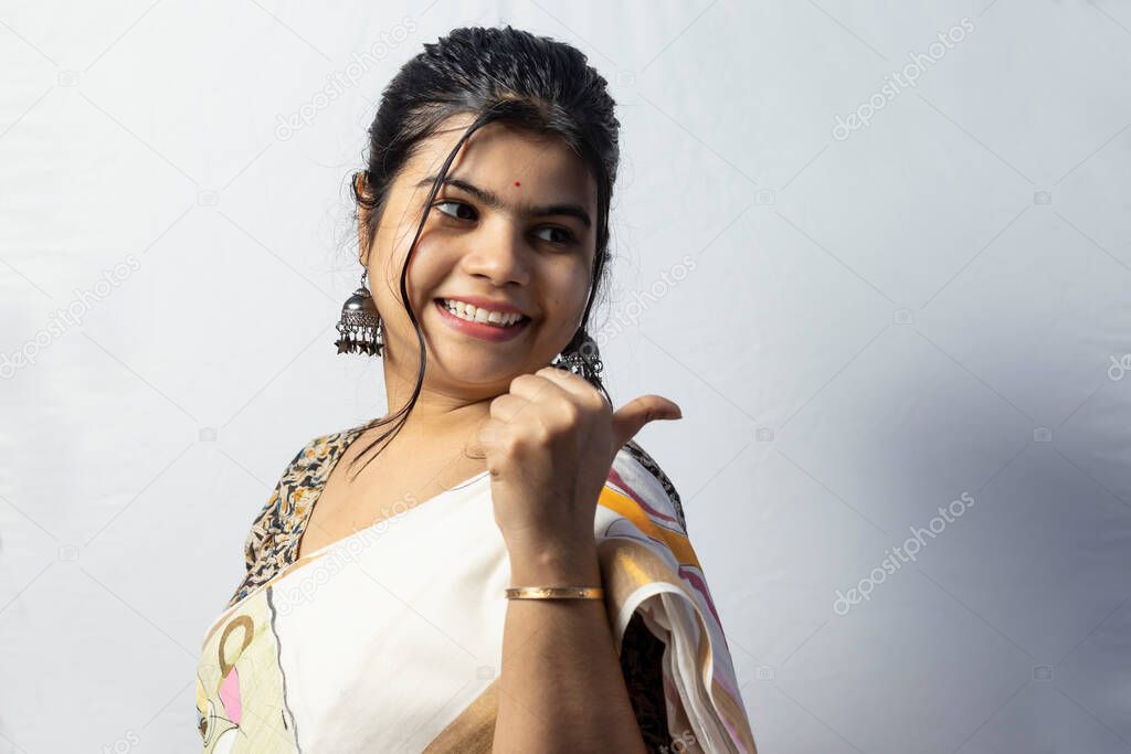 Isolated on white background an Indian female in saree showing empty space to her left on white background