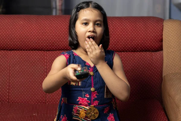 Индийская Девочка Зевает Смотря Телевизор Пультом Руке Сидя Диване — стоковое фото