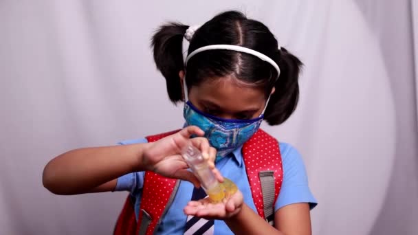 一名身穿蓝色校服 头戴红包鼻罩的印度女童灰色背景护手霜的画像 — 图库视频影像