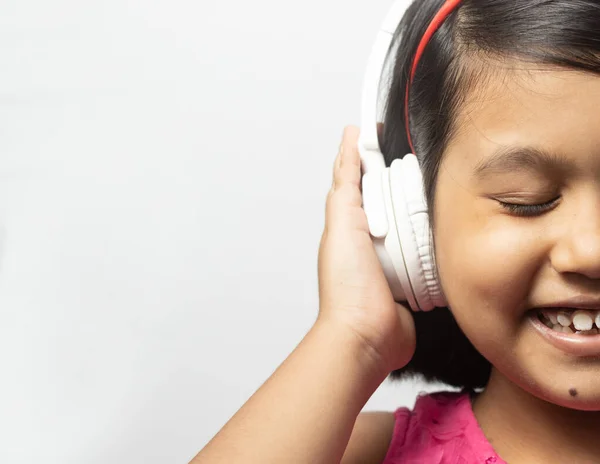 Zbliżenie Słodkie Indyjskie Dziecko Dziewczyna Słuchanie Muzyki Dotykając Biały Słuchawki — Zdjęcie stockowe