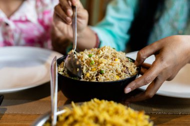 Tanımlanamayan bir çocuk, beyaz tabakta karışık pilav yiyor.