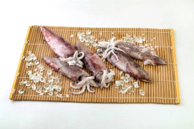 Hasır zemin üzerinde taze mürekkep balıkları ve buz..