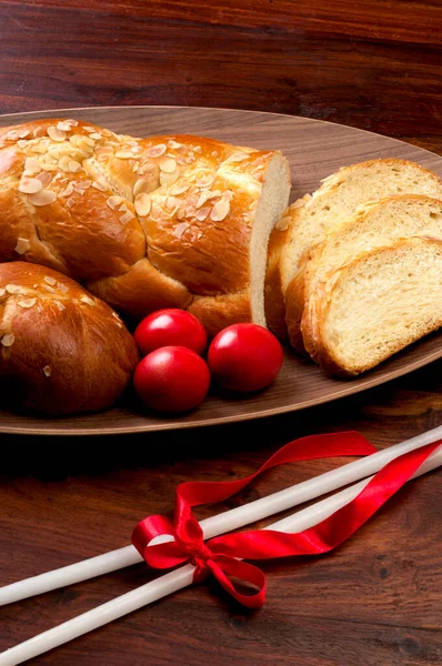 赤い卵とイースターテーブル 甘いパンとキャンドル — ストック写真