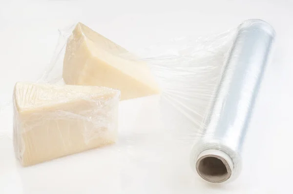 Piece of cheese wrapped with  cellophane ( cling) film for protection.