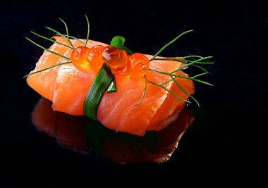 Siyah arka planda sarılmış somon ve kırmızı havyar.,