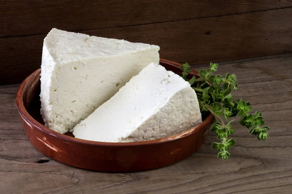 Geleneksel feta peyniri ahşap fıçılara dönüşüyor ve üçgen şeklinde kesiliyor..