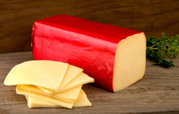 Ahşap Zemin Üzerinde Dilimlenmiş Edam Peyniri Bloğu — Stok fotoğraf
