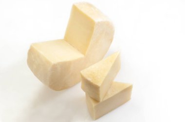 Beyaz arkaplanda parçalı tekerlek peyniri.