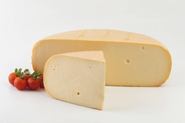 Tekerlek peyniri beyaz arkaplanda ikiye bölünmüş..