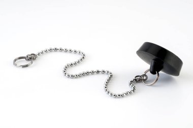 Lavabo ya da beyaz arka planda zincirli banyo giderleri için izole edilmiş siyah kauçuk tıpa. Seçici odak. 