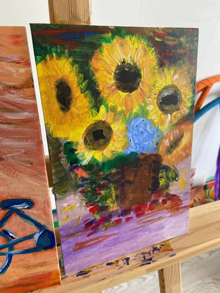 sunflowers in the picture.  oil painting. autumn bouquet.  painting on an easel.  yellow flower petals.