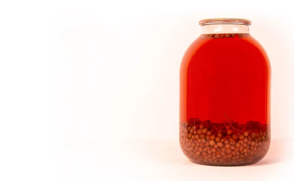 Glass jar with red berry juice. On a white background located sideways. copyspace for text. — Stock Photo, Image