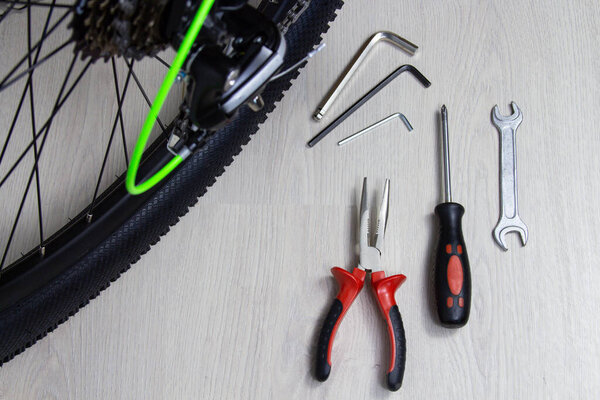 Bicycle and repair tools screwdriver wrench hex wrenches pliers cable cutter on wooden background