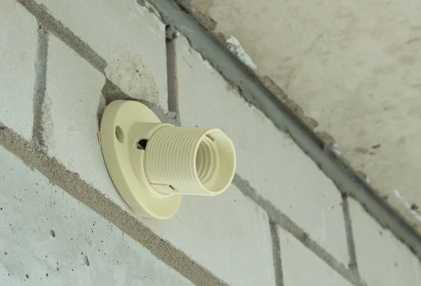 Presa elettrica in plastica per lampadina, parete in mattoni senza lampada. — Foto Stock