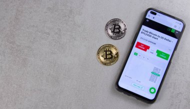 Bitcoin paraları cep telefonunun yanındaki masada yatıyor. e-ticaret konsepti