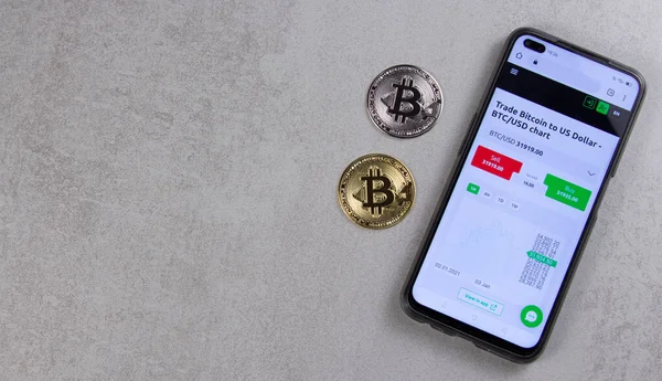 Bitcoin paraları cep telefonunun yanındaki masada yatıyor. e-ticaret konsepti
