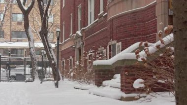 Tuğla binalar ve şehir manzarasına zamanla kar yağan bir sokak direği kış havası yaratıyor.