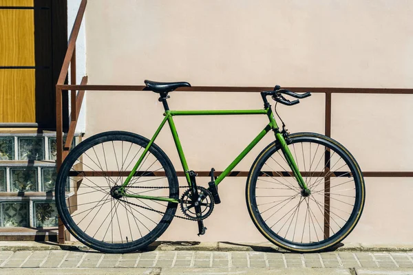 Old bicycle resting on a railing of a house