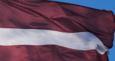 Ulusal Letonya bayrağı rüzgarda dalgalanıyor.