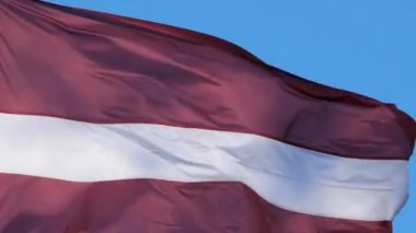 Ulusal Letonya bayrağı rüzgarda dalgalanıyor.