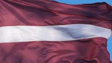 Ulusal Letonya bayrağı rüzgarda dalgalanıyor.