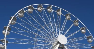  Dönme dolap mavi gökyüzüne karşı işliyor.