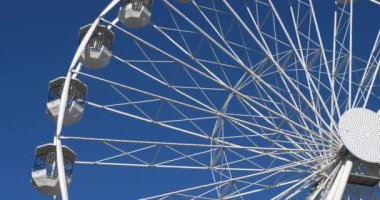  Dönme dolap mavi gökyüzüne karşı işliyor.