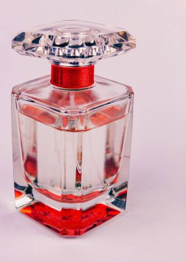 Pembe arka planda temiz cam parfüm şişesi.