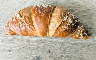 Dişbudak ahşap bir masanın yüzeyinde pişmiş kruvasan.