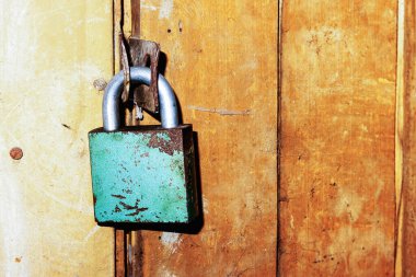 Bir evin bodrumundaki eski ahşap kapıya boyanmış antika bir kilit.