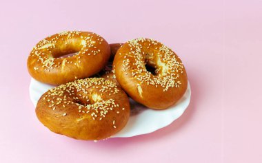 Pembe arka planda bir tabakta delik olan haşlanmış ve kızartılmış rulo.