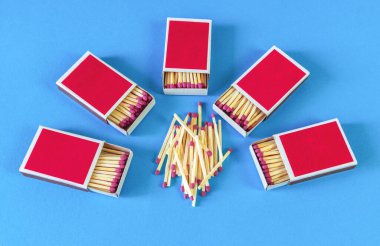 Kağıt kırmızısı kibrit kutuları mavi arkaplanda daire şeklinde dizilmiş.