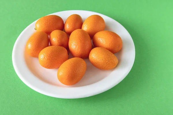 Fortunella Fondo Verde Frutta Kumquat Matura Piatto Bianco — Foto Stock