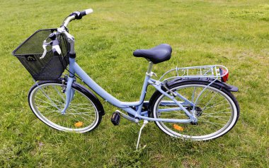 Çayırda asılı duran çantalı bir kadın bisikleti.