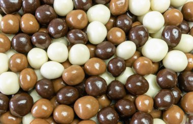 Farklı renkli çikolata toplarının arka planı dağınık ve üst bir manzarada düzenlenmiştir.