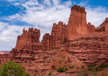 Fisher Towers 'ın ana yürüyüş yolunun bir panoraması geniş bir alanı kaplayan kırmızı kaya oluşumlarını gözler önüne serer.