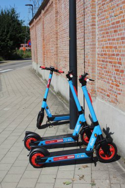 AALST, BELGIUM, 25 AĞUSTOS 2021: Aalst 'ta bir kaldırıma park etmiş bir grup' Dott 'elektrikli scooter. Mobiletler, kentte daha yeşil ulaşım sağlama girişimi kapsamında kiralanabilir..