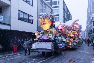 AALST, BELGIUM, 15 Şubat 2026: Aalst Karnavalı 'nda kar fırtınası yıllık sokak geçidini vururken karla kaplı karnaval şamandıraları. Geçit töreni Flanders 'taki en büyük Mardi Gras etkinliği..