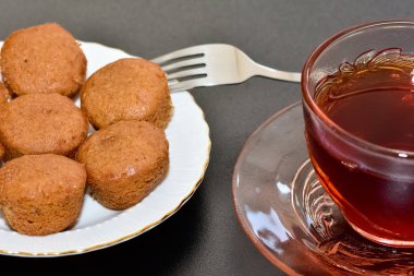 Beyaz bir tabakta ev yapımı kek ve çay fotoğrafı.