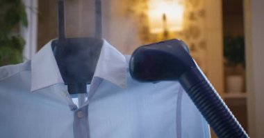 Mavi gömlek buhar ütüsüyle ütülenir.