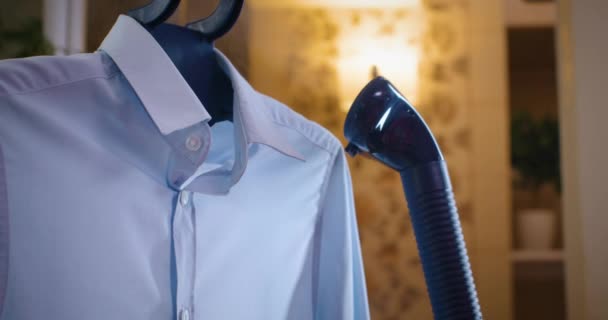 Das blaue Hemd wird mit einem Dampfbügeleisen gebügelt — Stockvideo